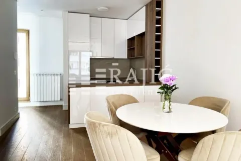 Modern kitchen with a dining table and white cabinets. - image 5