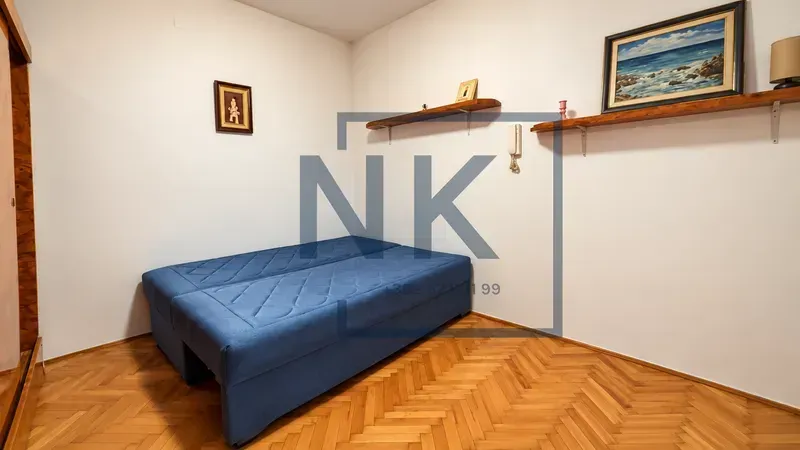 Bedroom with a bed and wooden flooring.
