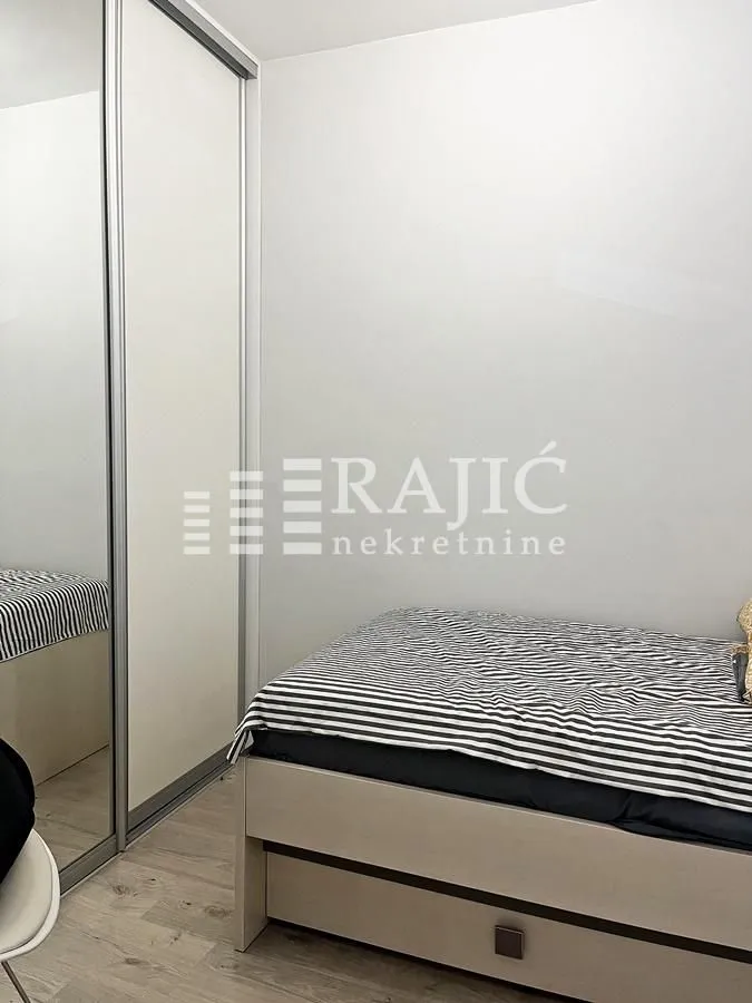 Smaller bedroom with a bed and a built-in mirrored wardrobe.