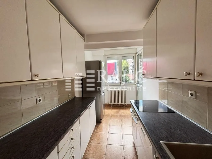 Small kitchen with white cabinets and dark countertops.