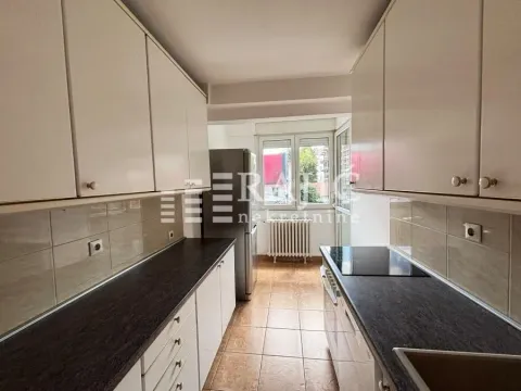 Small kitchen with white cabinets and dark countertops. - image 9