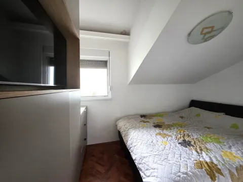 Small bedroom with a double bed and built-in furniture under a sloped ceiling. - image 8