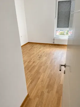 Prazna soba sa drvenim parketom i prozorom. - image 6