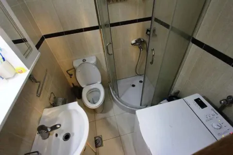 Kompaktno opremljeno kupatilo sa tuš kabinom, umivaonikom, WC šoljom i veš mašinom. - image 8