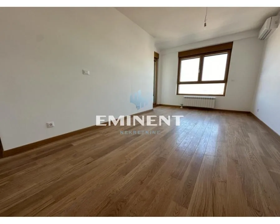 Empty room with wooden flooring and a window.
