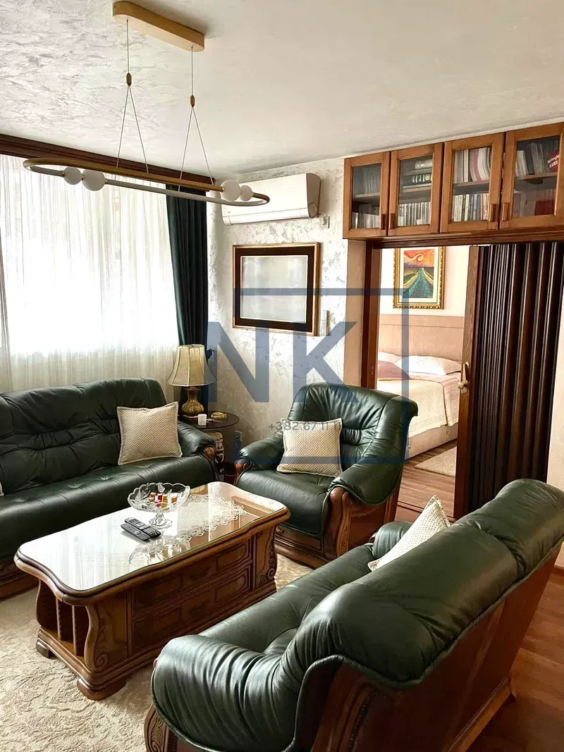 Living room with green leather sofas and a coffee table.