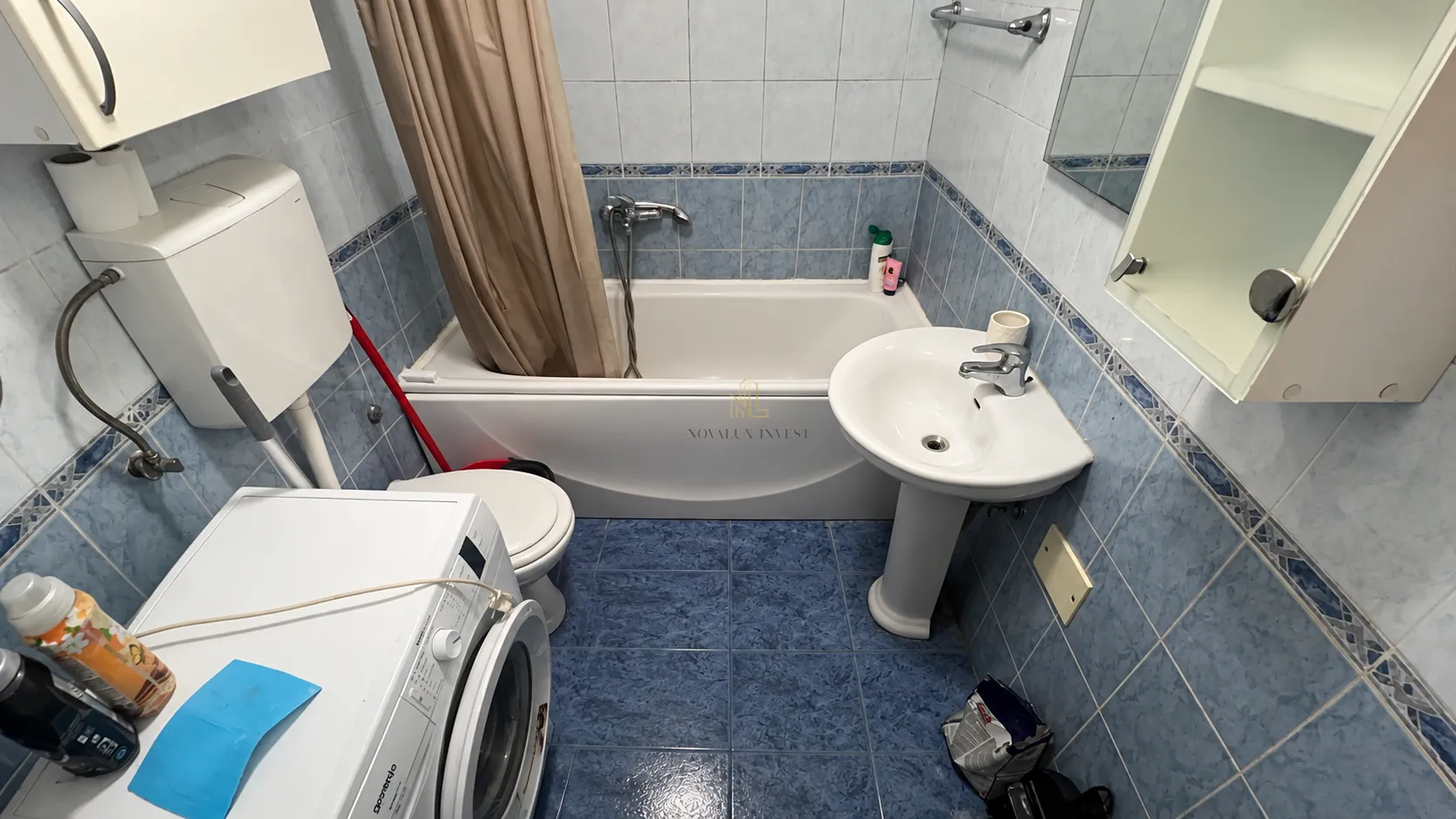 Kupatilo opremljeno kadom, umivaonikom, WC šoljom i veš mašinom.