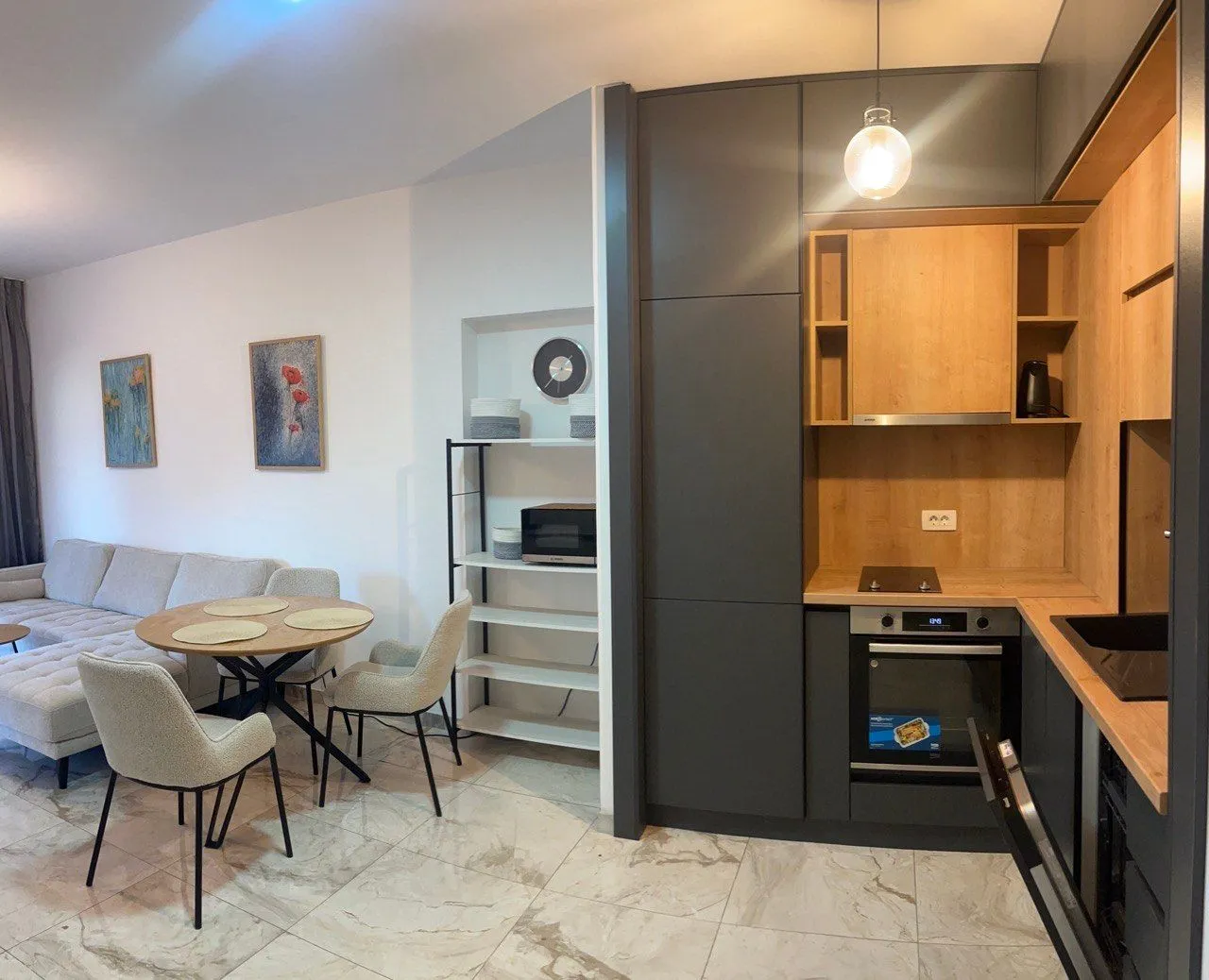Modern kitchen with a dining area and living room in light tones.