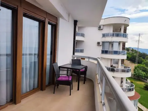 Spacious balcony with seating furniture and a view of the surroundings. - image 8