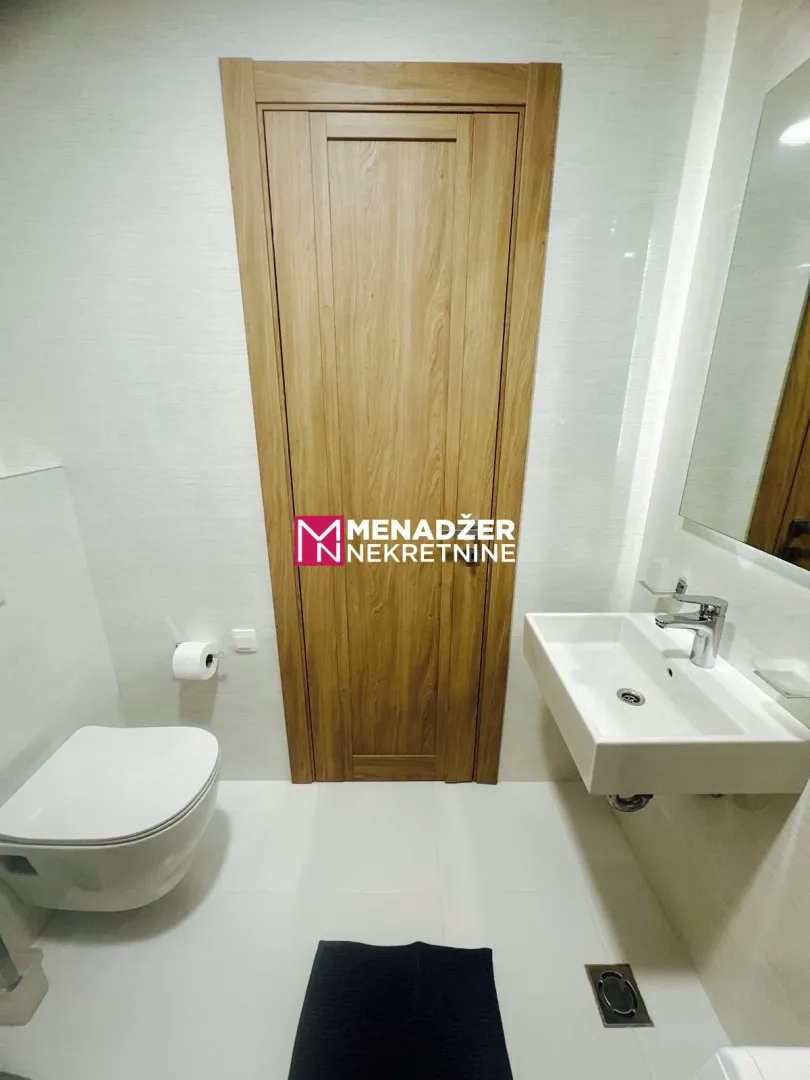 Modernly equipped bathroom with a washbasin and toilet.