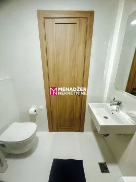 Modernly equipped bathroom with a washbasin and toilet. - image 7
