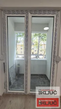 Pogled kroz balkonska vrata na terasu i okolne zgrade. - image 10