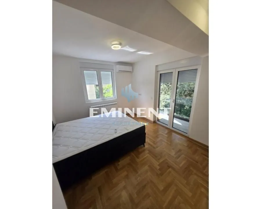 Bedroom with a double bed, parquet flooring, and access to the terrace.