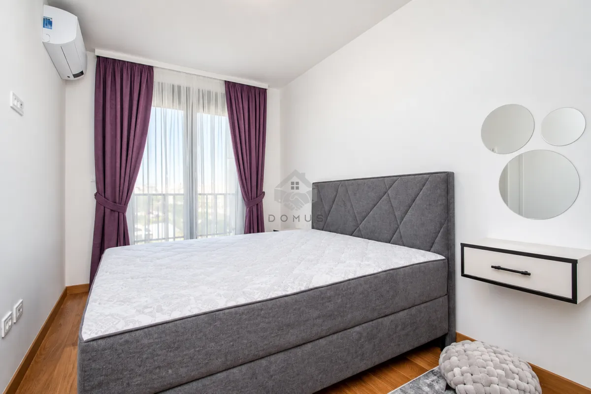 Bedroom with a double bed, purple curtains, and wall mirrors.