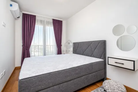Bedroom with a double bed, purple curtains, and wall mirrors. - image 7