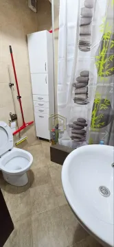 Manje kupatilo sa umivaonikom, WC šoljom, tuš kabinom i bijelim ormarićem. - image 5