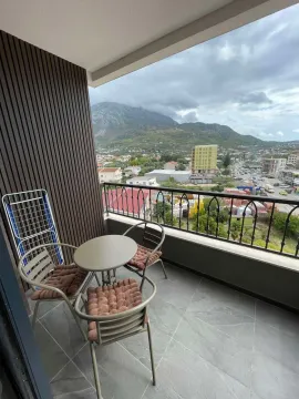 Furnished terrace with a table, chairs, and a view of the city and mountains. - image 7