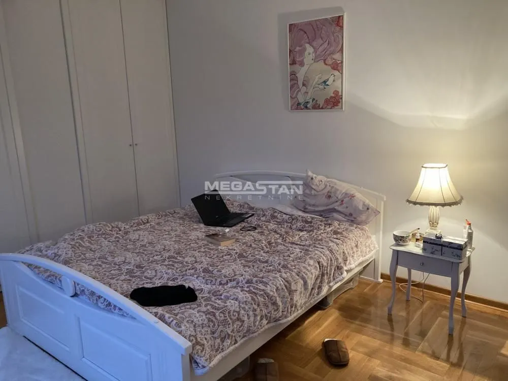 Spavaća soba sa bračnim krevetom, garderoberom i noćnim stočićem.