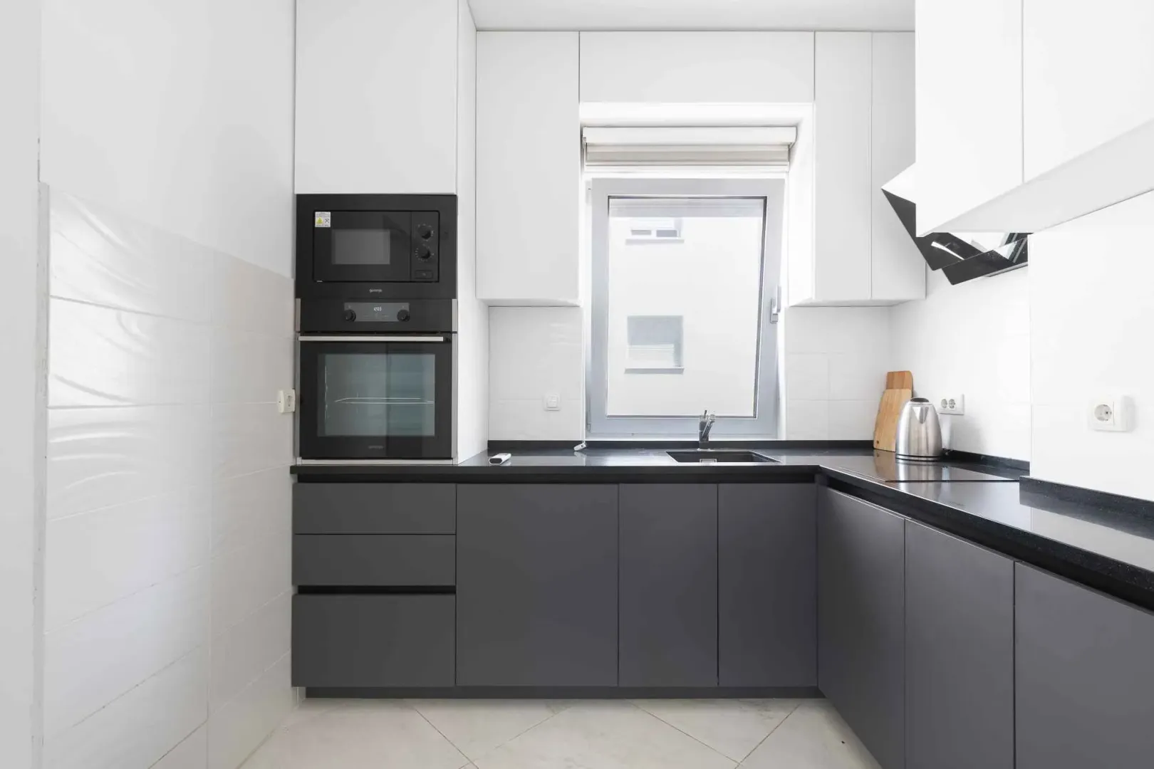 Modern kitchen with grey cabinets and built-in appliances.