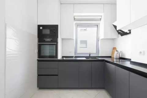 Modern kitchen with grey cabinets and built-in appliances. - image 12