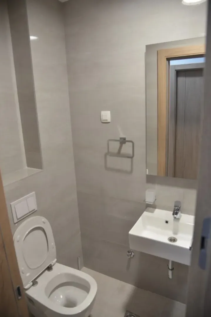 A small modern bathroom with a toilet and sink.