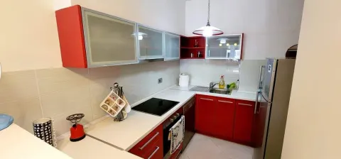 Smaller kitchen with red cabinets and built-in appliances. - image 3