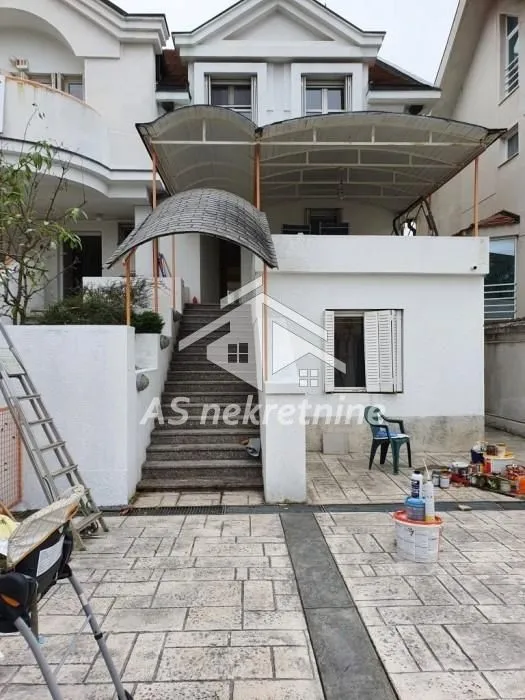 View of the yard and house entrance with stairs and a covered terrace.