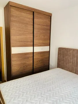 Bedroom with a double bed and a large wooden wardrobe. - image 9