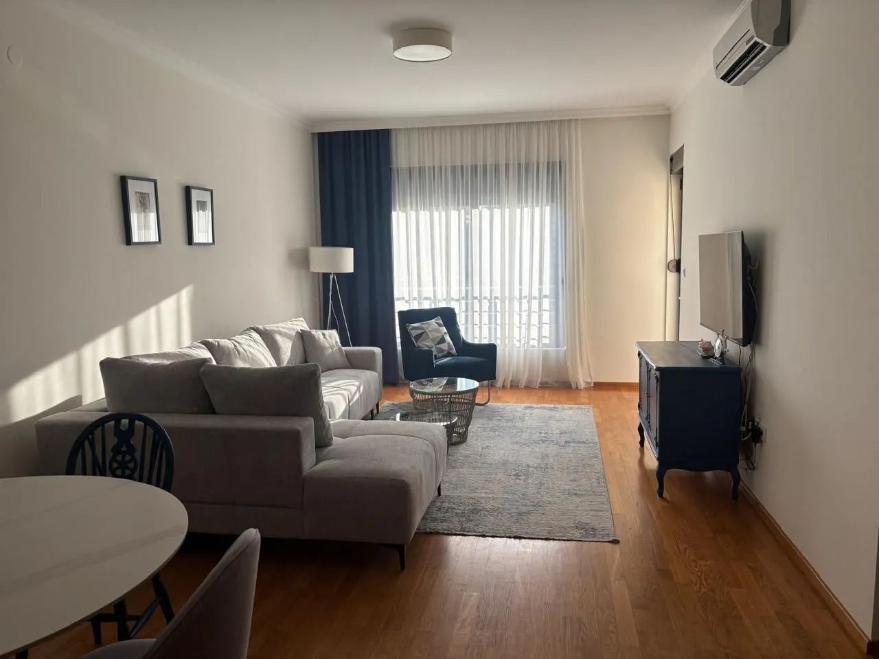 Living room with sofa, TV, and dining table.