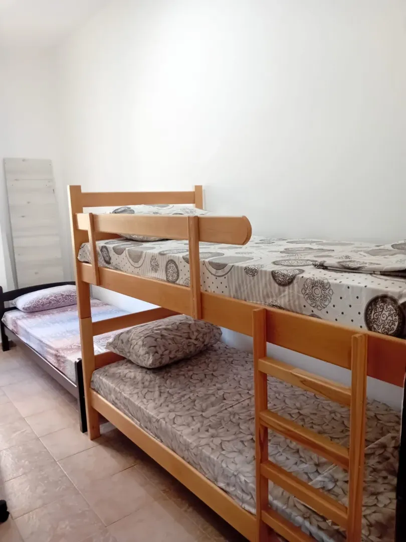 Spavaća soba sa krevetom na sprat i dodatnim ležajem.
