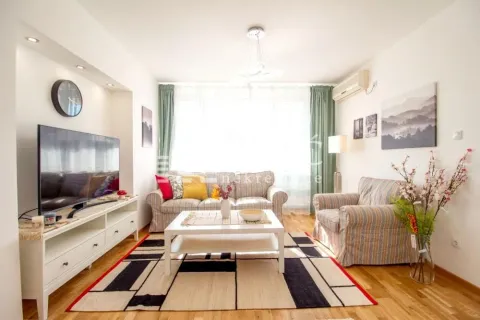 Furnished living room with a sofa set, TV, and rug. - image 2
