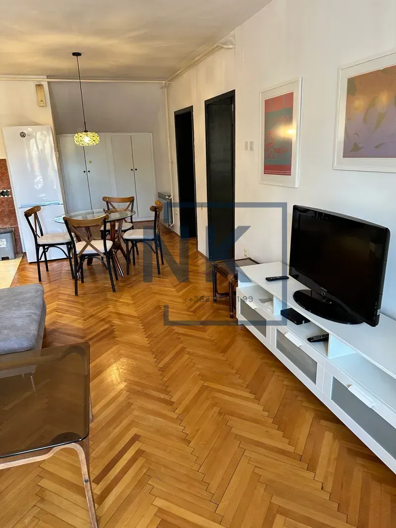 Living room with a dining area and parquet flooring.