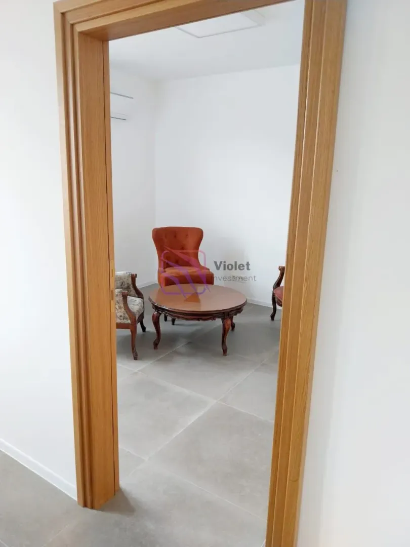 View from the hallway into a small room with armchairs and a wooden coffee table.