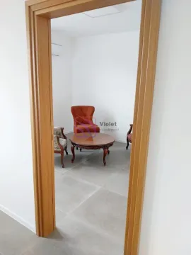 View from the hallway into a small room with armchairs and a wooden coffee table. - image 4