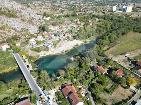 Pogled iz vazduha na rijeku i okolno naselje sa kućama. - image 2