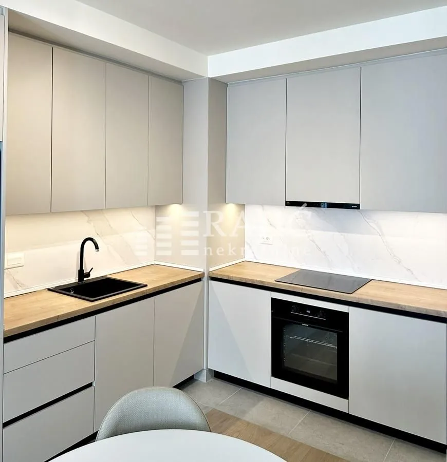 Modern kitchen with light cabinets and built-in appliances.
