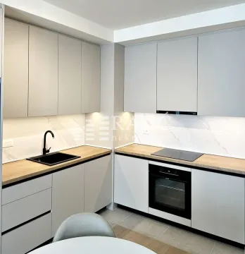 Modern kitchen with light cabinets and built-in appliances. - image 6