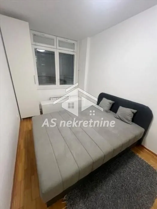 Furnished bedroom with a double bed, wardrobe, and window.