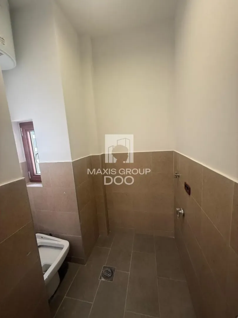View of the bathroom with tiled flooring and sanitary elements.