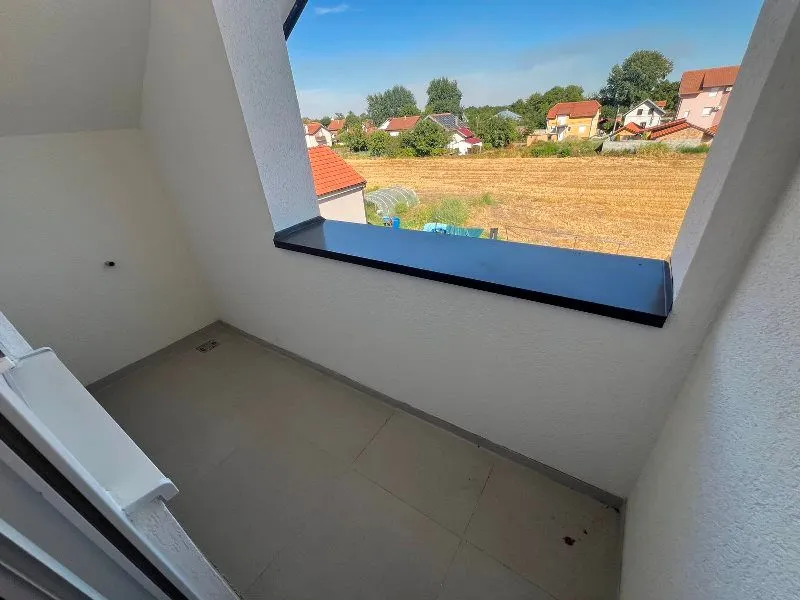 Nenamešten balkon sa pogledom na okolinu.