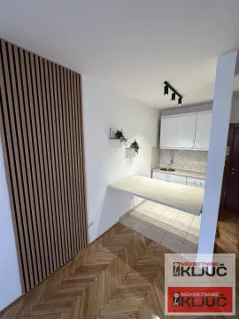 Manja kuhinja sa belim elementima i šankom povezana sa trpezarijom. - image 5
