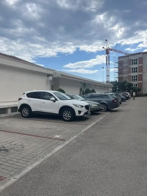 Vanjski dio objekta sa uređenim parking prostorom.