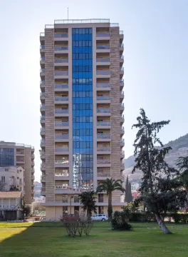 View of the front facade of a multi-story residential building with a landscaped yard. - image 4