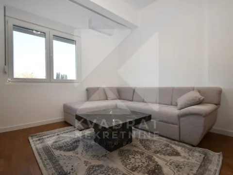 Living room with a sectional sofa, coffee table and air conditioner. - image 3