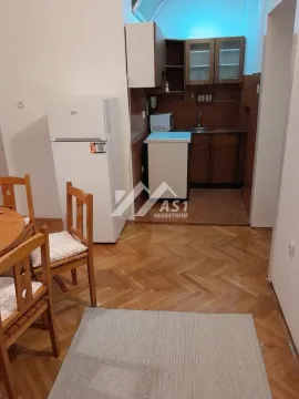 Manja kuhinja sa drvenim elementima i trpezarijskim stolom u nastavku. - image 4