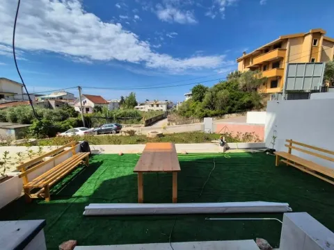 Terrace with a wooden table and benches in front of the house. - image 5