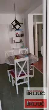 Trpezarija sa stolom i belim stolicama. - image 8