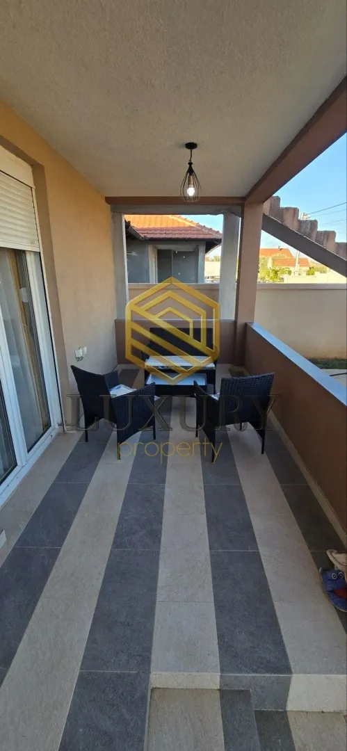 Covered balcony with seating furniture.