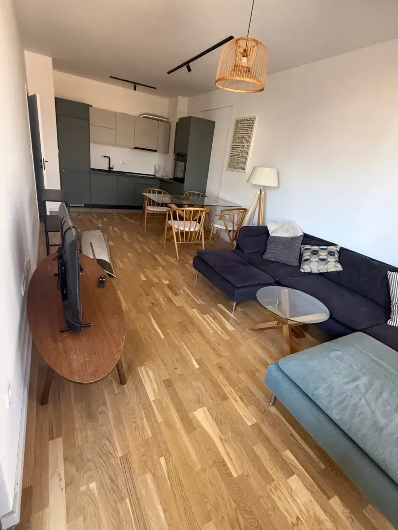 Living room with dining area and kitchen in an open space.
