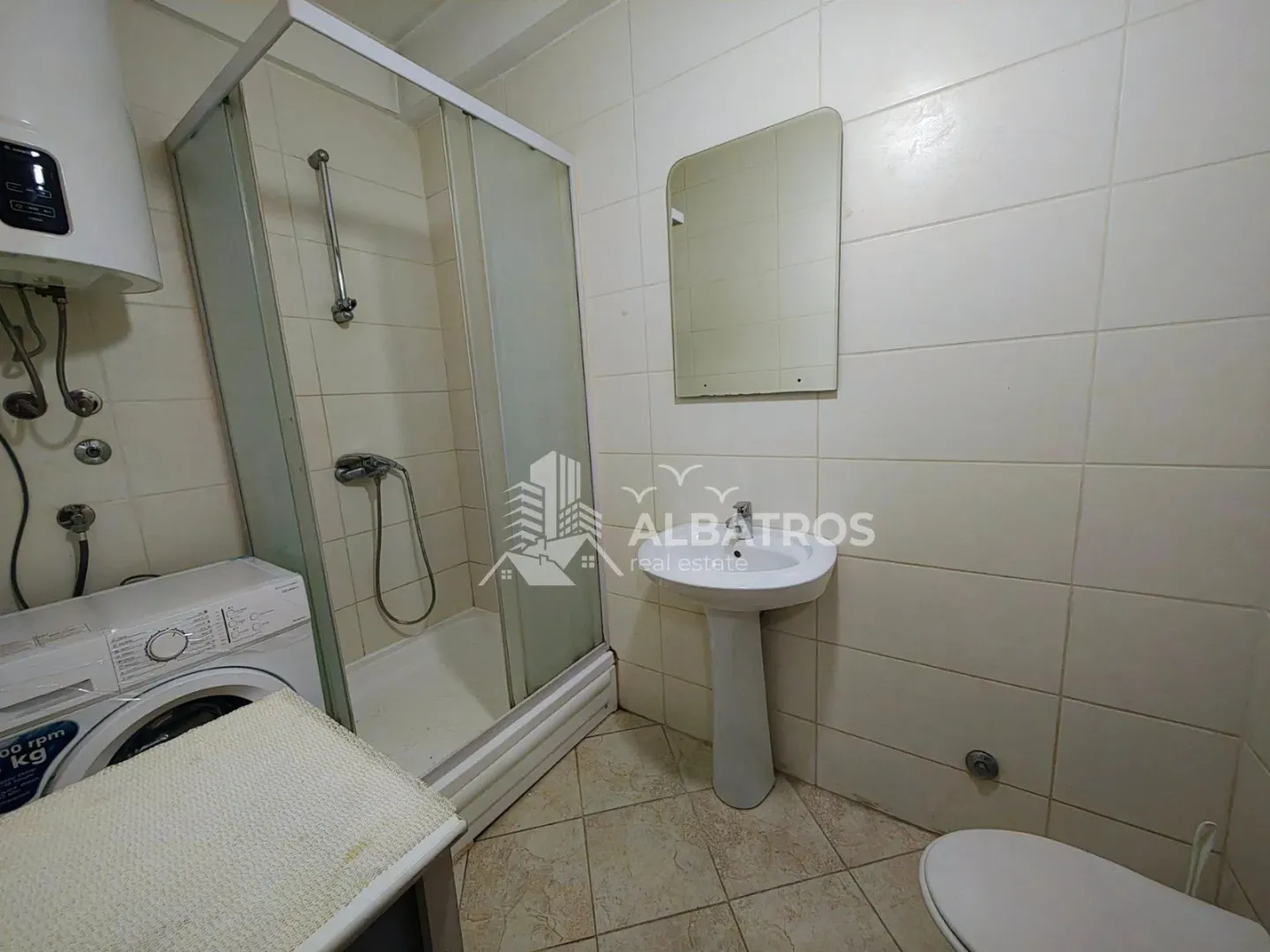 Kupatilo sa tuš kabinom, umivaonikom, WC šoljom i veš mašinom.